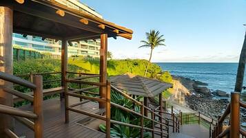 A wooden deck with a view of the ocean and a building in the background.