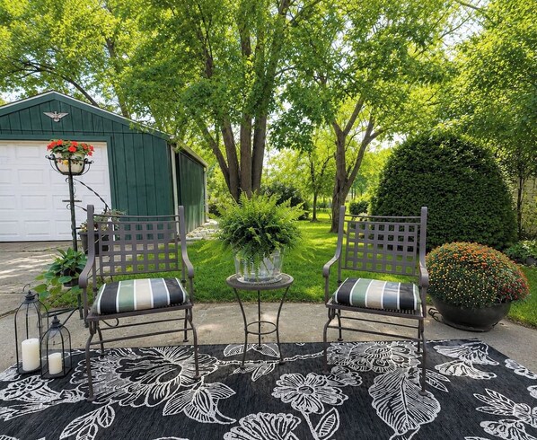 A patio with two chairs, a table, and a potted plant. - King Bed • Vintage Urban Oasis • Near MKE Airport (Milwaukee)
