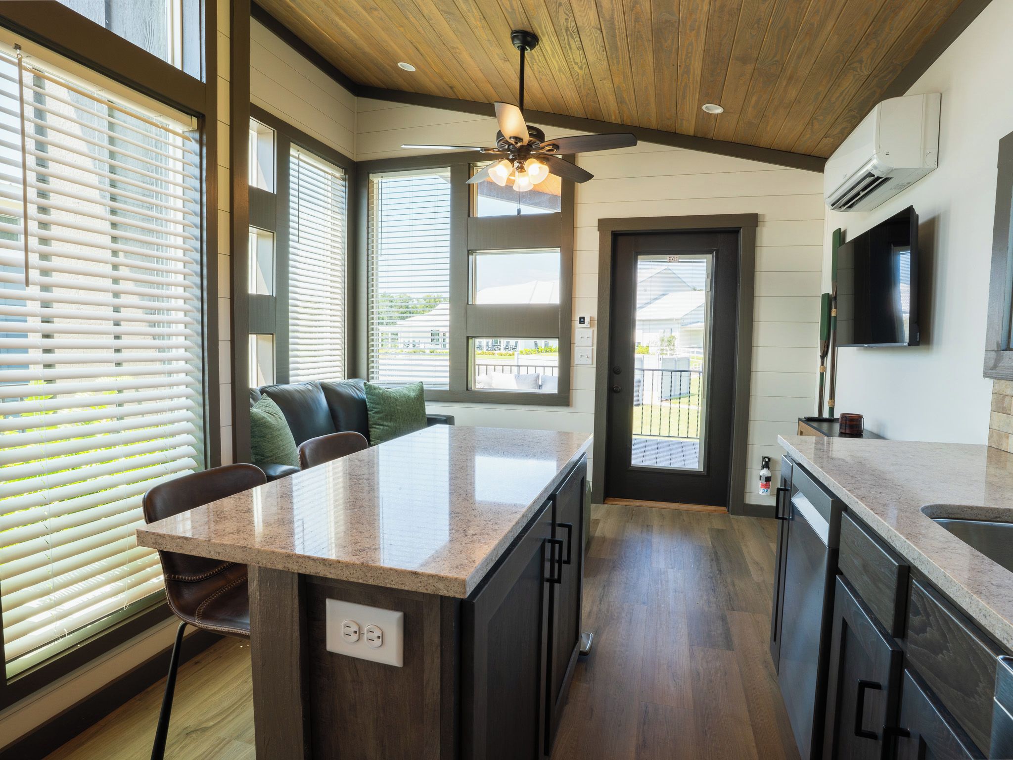 A modern kitchen with a central island, built-in appliances, and large windows.
