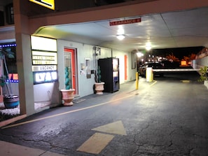 Entrada de hotel con un letrero que indica una altura libre de 2.4 metros, un cartel de habitaciones limpias y un letrero de disponibilidad.