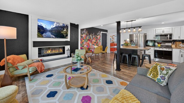 A modern living room with a fireplace, a dining area, and a kitchen with white cabinets. - Gather at 104 - Walk to Downtown Perrysburg (Perrysburg)