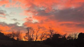 A sunset with a wooden fence in the foreground.