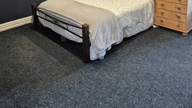 Un dormitorio con cama, cómoda y mapa colgado en la pared.