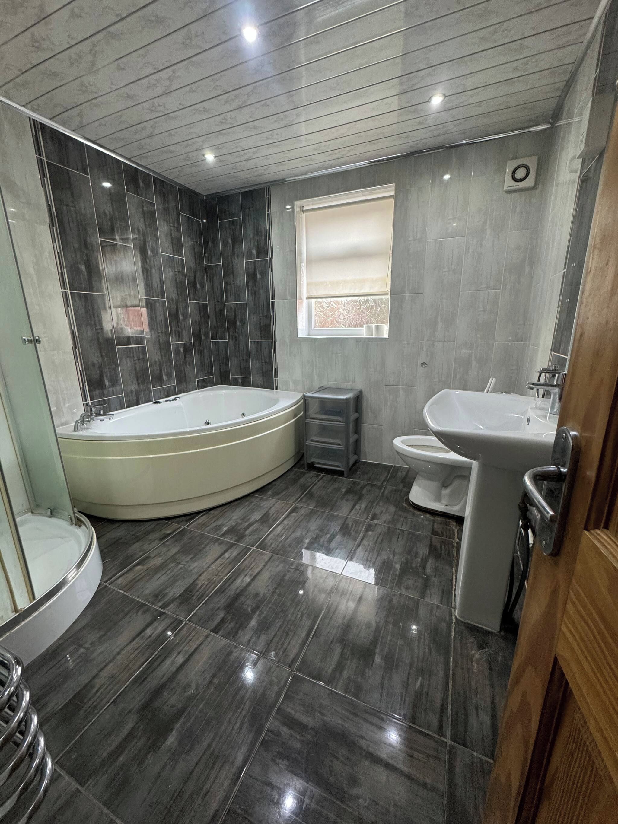 A modern bathroom with a bathtub, toilet, and sink.