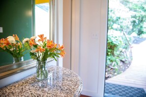 A glass vase with flowers on a granite countertop near a window. - Sunset Room at Buckhorn Cove near Mendocino w/ Ocean View, Dog-Friendly, EV Chgr (Mendocino County)