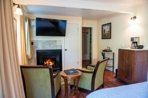 A hotel room with a fireplace, a television, a dining area, and a bed. - Meadow Room at Buckhorn Cove near Mendocino - Cozy Gas Fireplace & EV Charger (Mendocino County)