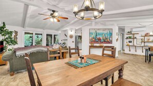 Ein geräumiger Essbereich mit Holztisch, Stühlen und Deckenventilator.