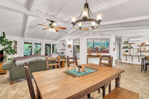A spacious dining area with a wooden table, chairs, and a ceiling fan. - Desert Retreat | Hot Tub & Mountain Views (Tucson)