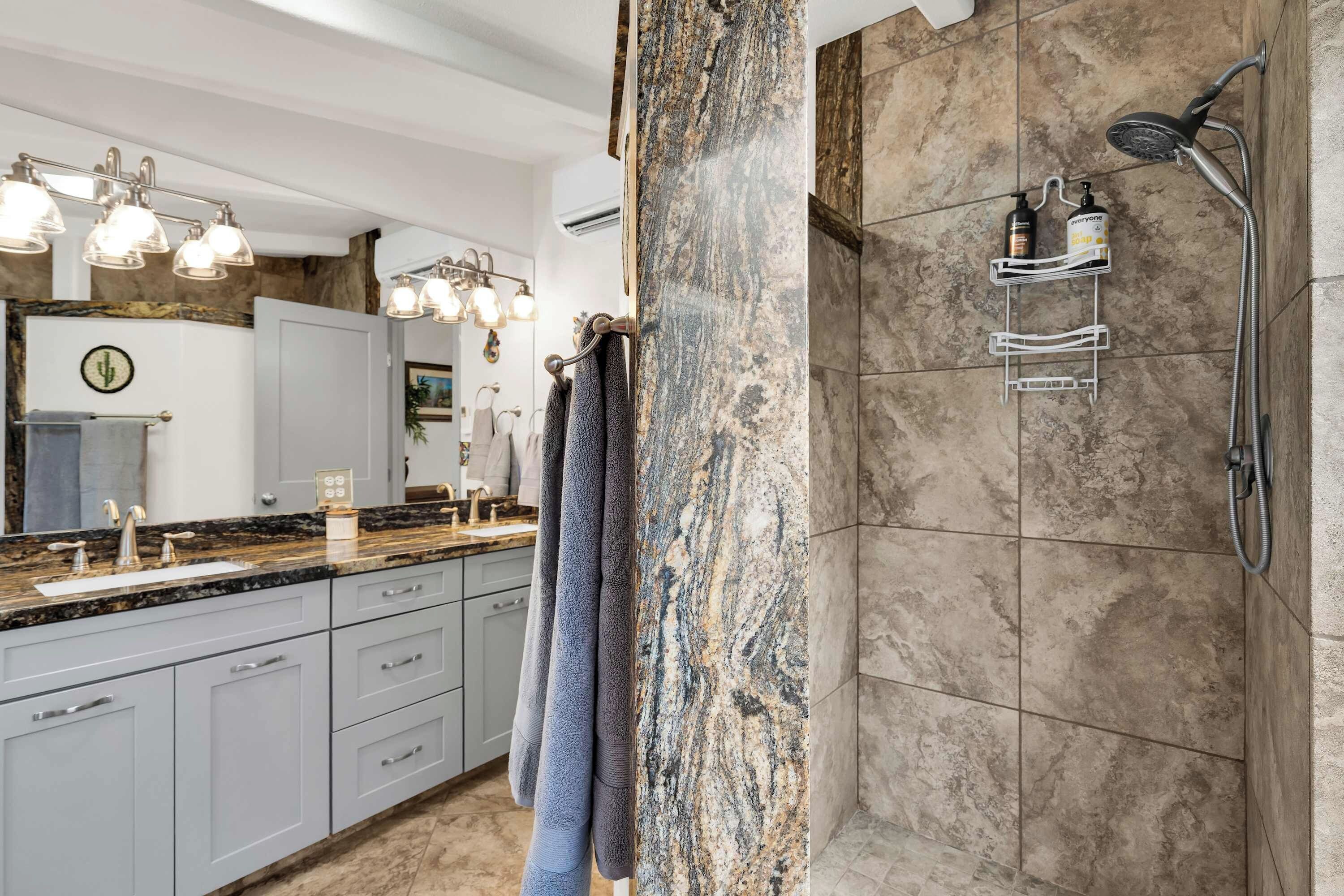 A modern bathroom with a shower, a vanity with a sink, and a towel rack.