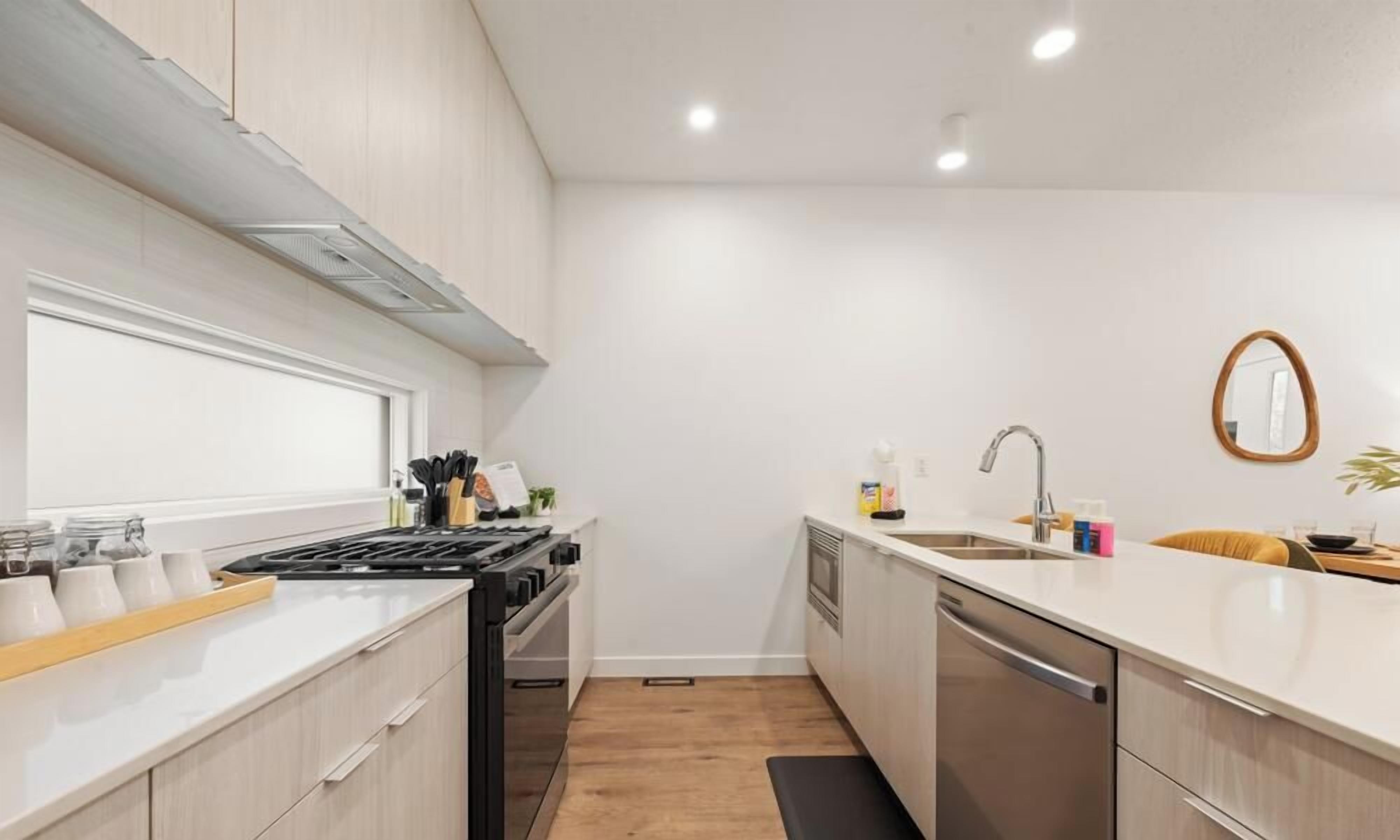 A compact kitchen with a stove, sink, and dishwasher.