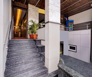 A staircase leading to a room with a marble wall and a vending machine. - Deluxe With Twin Bed Hotel Metro Park (Bengaluru)