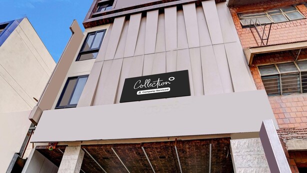 A multi-story building with a prominent sign for 'Collection Company-Serviced'. - Deluxe With Twin Bed Hotel Metro Park (Bengaluru)