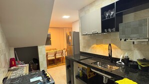 Uma cozinha moderna com fogão a gás, forno embutido, micro-ondas e pia.