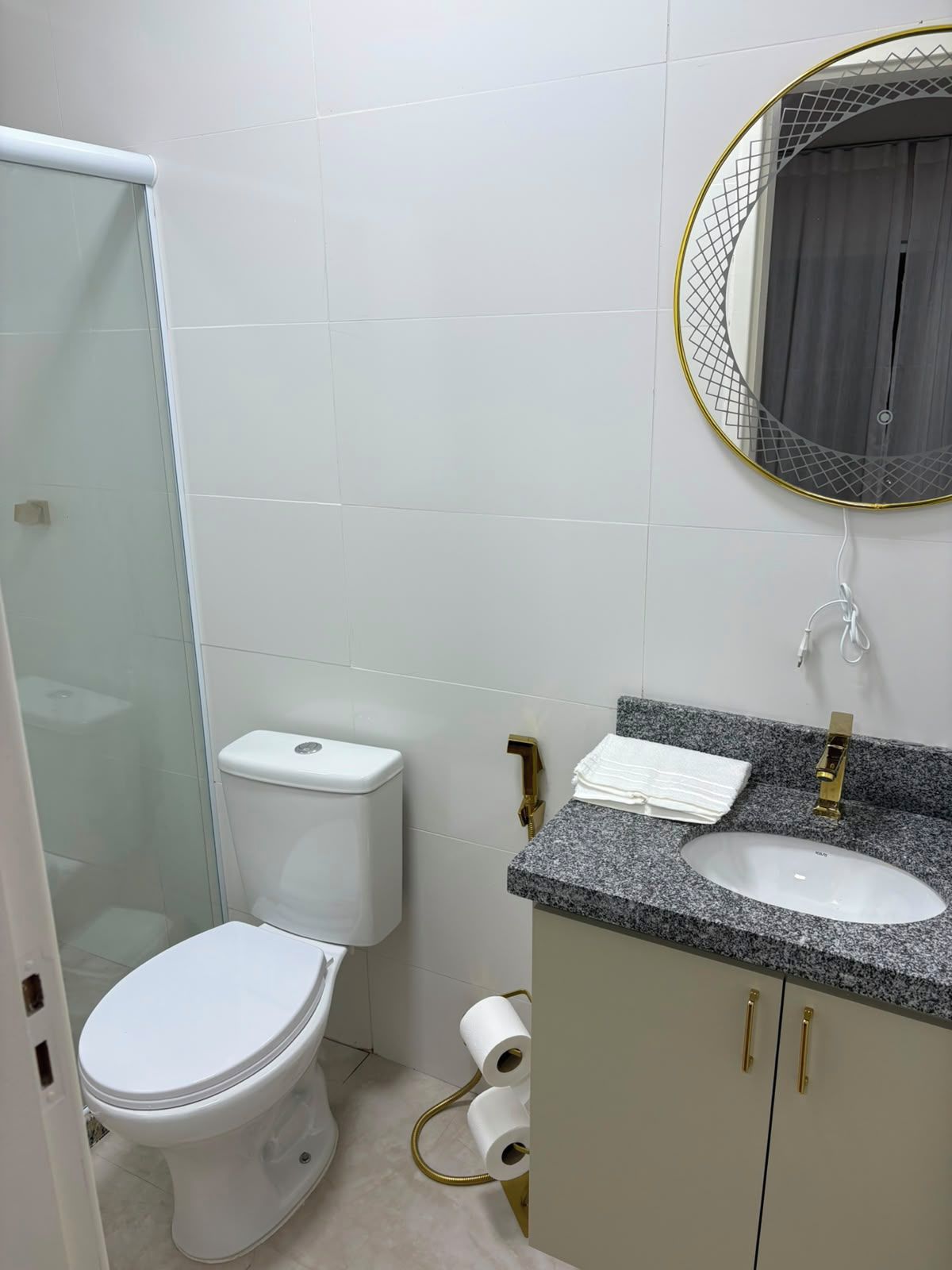 A bathroom with a toilet, a sink, and a shower area.