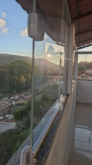 A balcony with a view of a road and hills.