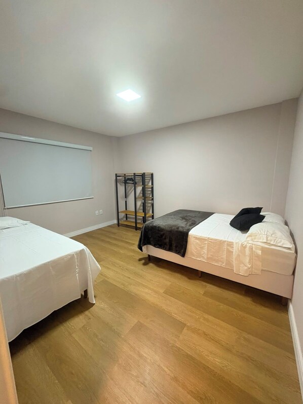 A room with two beds, a whiteboard, and a wooden floor. - New apartment in Santa Teresa-ES, enclosed balcony with mountain views. (Santa Teresa)