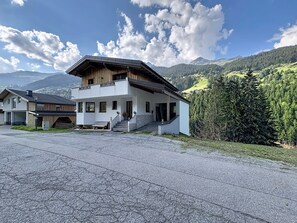 A two-story building with a balcony, a stone staircase, and a view of a mountainous landscape. - Alpenblick by Interhome (See)