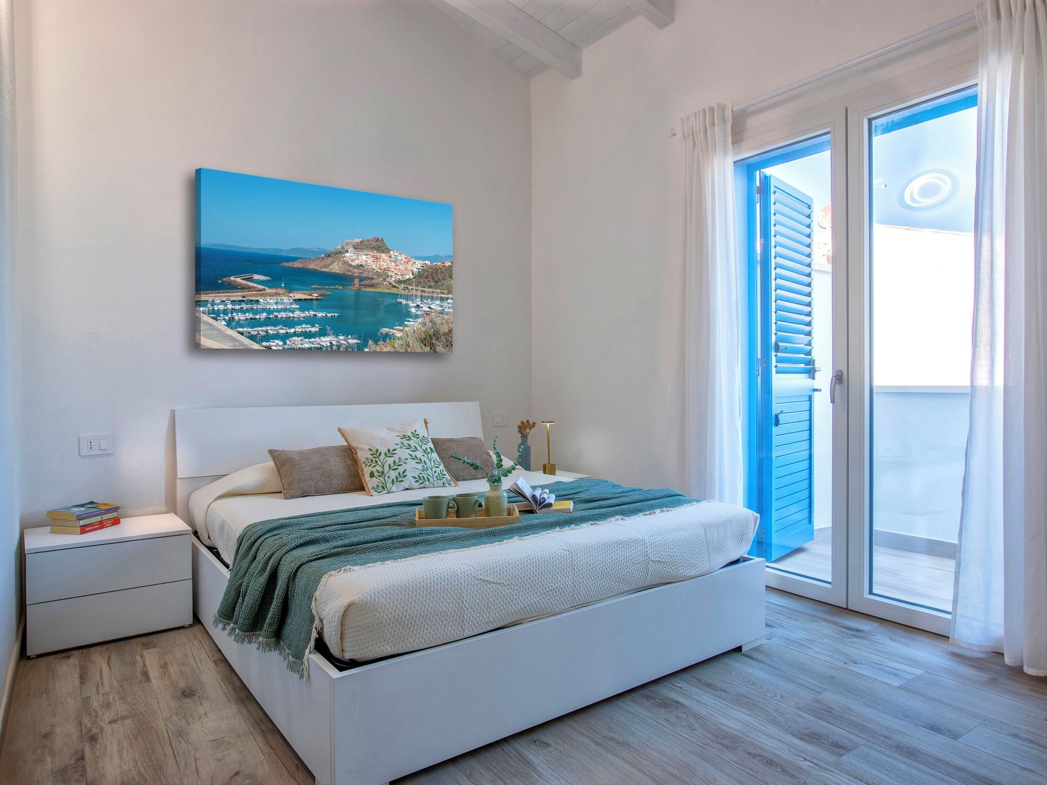 Una camera da letto con un letto, un comodino e vista mare da una finestra.