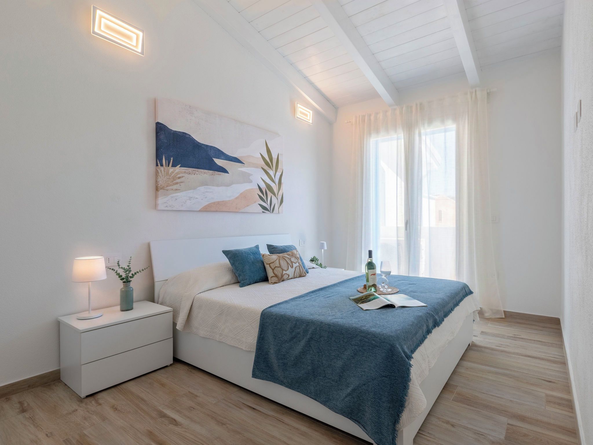 Una camera da letto moderna con un letto, un comodino e un quadro appeso al muro.