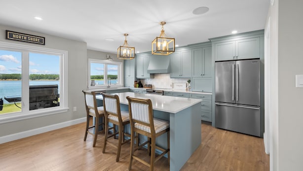 A kitchen with a large island, bar stools, stainless steel appliances, and a view of the outdoors. - Private PEI Waterfront Escape | 5BR | Dock | Beach | Golf & Cavendish Nearby (Kensington)