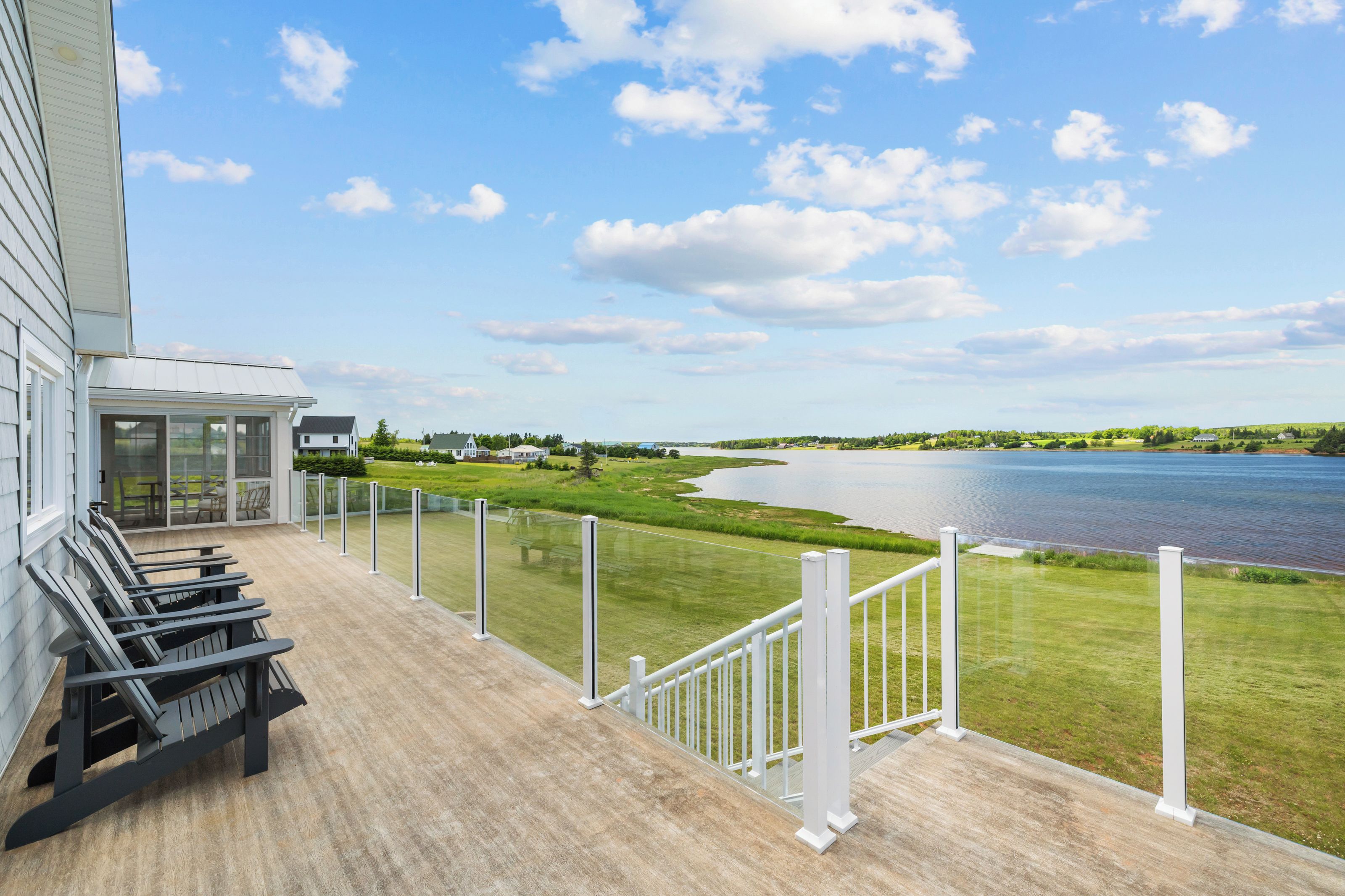 A deck with outdoor seating and a view of a lake.