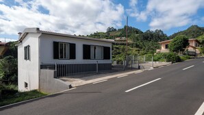 Un bâtiment moderne doté d’un toit plat, d’une base en béton et d’une clôture métallique à l’avant.