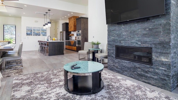 A modern living space with a fireplace, a dining area, and a kitchen. - Luxury Golf Course-View - Heated Pool & Hot Tub (Hurricane)