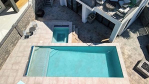 A rooftop pool area with a large pool and a smaller pool, surrounded by outdoor seating and a staircase leading to a balcony with a seating area. - Luxury Golf Course-View - Heated Pool & Hot Tub (Hurricane)