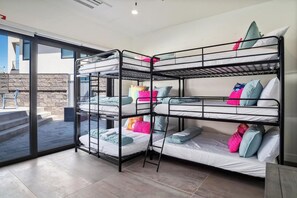 A bunk bed room with a glass door leading to an outdoor area. - Luxury Golf Course-View - Heated Pool & Hot Tub (Hurricane)