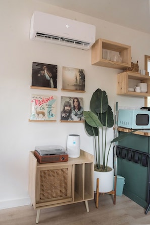 A room with a vintage radio, a potted plant, and wall art. - The Getaway · Cozy cabin, Hot tub, Outdoor shower (Valley Mills)