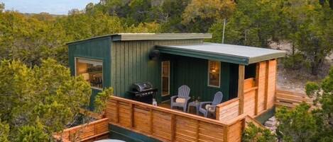 A cabin with a hot tub, outdoor seating, and a deck.