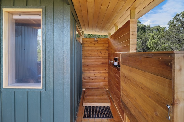 A wooden sauna with a window and a showerhead. - The Getaway · Cozy cabin, Hot tub, Outdoor shower (Valley Mills)