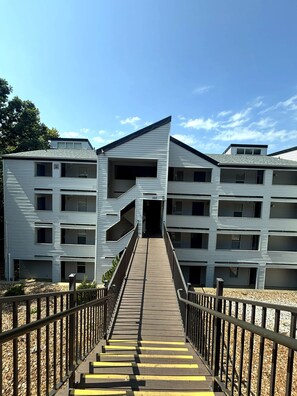 A multi-story building with a central staircase leading to an entrance. - Bridgepointe Lake Escape (Osage Beach)