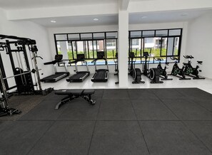 Ein Fitnessstudio mit Laufbändern, Ergometer und Gewichten.