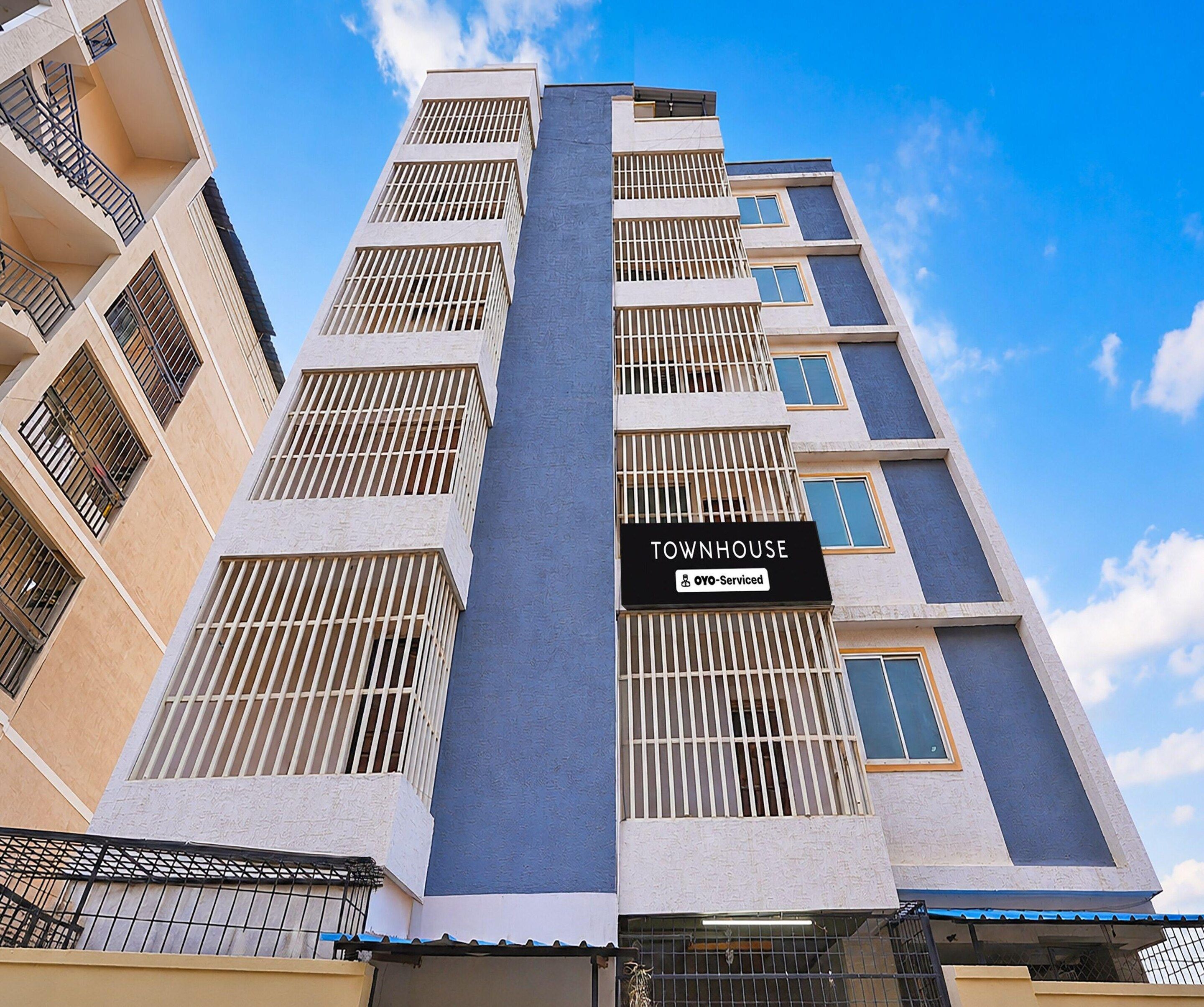 A multi-story building with a sign indicating it is serviced by OYO.
