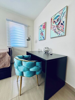 A modern bedroom with a bed, a desk, and two wall-mounted artworks. - Modern Relaxing Vacation Villa (Oranjestad)