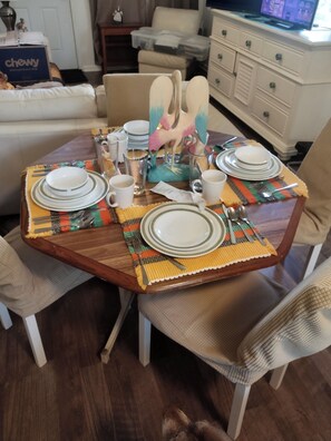 A dining table set with plates, glasses, and cutlery, surrounded by chairs. - Private apartment in downtown Tallahassee. Private entrance. Access to backyard. (Tallahassee)