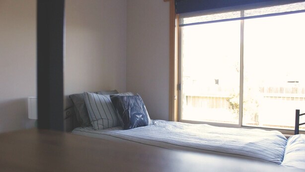 A room with a bed, a window, and a view of the outside. - Quaint Country Home (Westbury)