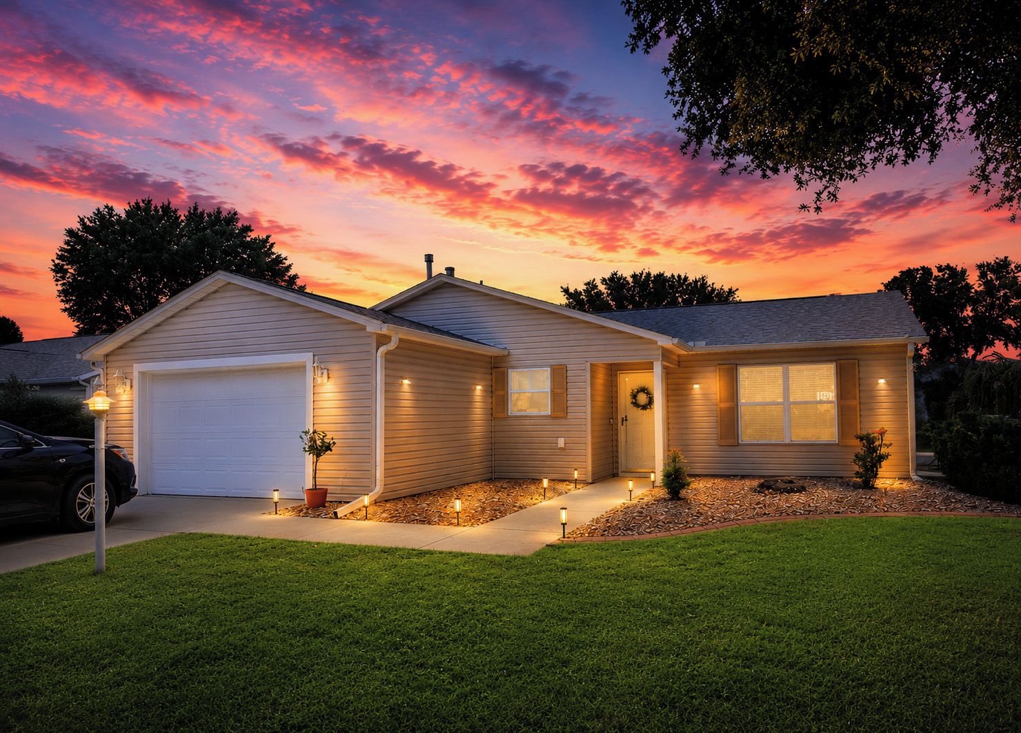 A single-story house with a garage, front porch, and a small lawn.