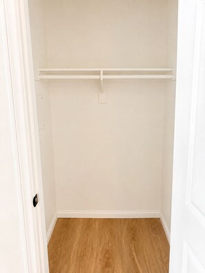A closet with a wooden floor and white walls. - Paradise Park! - Modern Downtown Studio, King Bed + Balcony + Parking (San Diego)