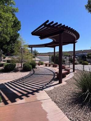 A covered outdoor area with a curved pathway, benches, and a pergola structure. - Peaceful Poolside Perfection!  4 bedroom 3-with King Beds & ensuites, 4-1/2 bath (Washington)