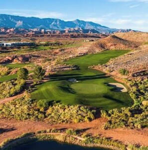 A golf course with a pond, surrounded by rocky terrain and mountains. - Peaceful Poolside Perfection!  4 bedroom 3-with King Beds & ensuites, 4-1/2 bath (Washington)