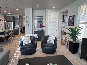 A living room with two black leather chairs, a coffee table, and a potted plant. - Peaceful Poolside Perfection!  4 bedroom 3-with King Beds & ensuites, 4-1/2 bath (Washington)