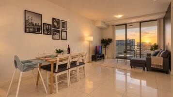 Una sala de estar moderna con comedor, ventanas amplias y vista a la ciudad.