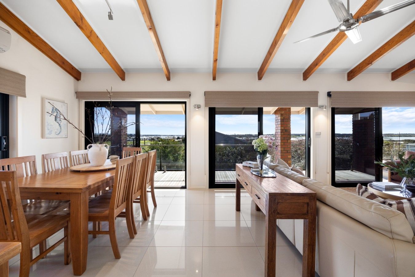 A spacious room with a dining area, a sofa, and a view of the outdoors.