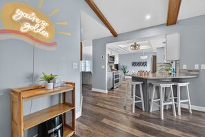 A modern kitchen with a bar area, wooden flooring, and a neon sign on the wall. - VILLA CORAL CABANA – HEATED POOL | WATER VIEW | PUTTING GREEN | BOAT RENTAL + TOURS VOUCHER INCL. (Cape Coral)