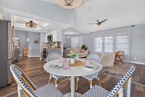 A spacious living area with a dining table, chairs, and a kitchen in the background. - VILLA CORAL CABANA – HEATED POOL | WATER VIEW | PUTTING GREEN | BOAT RENTAL + TOURS VOUCHER INCL. (Cape Coral)