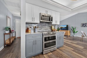 A modern kitchen with grey cabinetry, a stainless steel range, and a built-in oven. - VILLA CORAL CABANA – HEATED POOL | WATER VIEW | PUTTING GREEN | BOAT RENTAL + TOURS VOUCHER INCL. (Cape Coral)