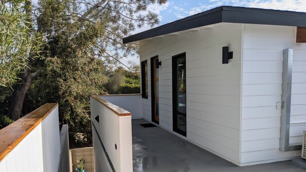 A modern building with a flat roof, white exterior walls, and a concrete floor. - Charming studio in quiet neighborhood with great views. 10 minutes from beaches (Encinitas)