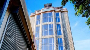Un immeuble d’angle à la façade en briques et doté de nombreuses fenêtres.